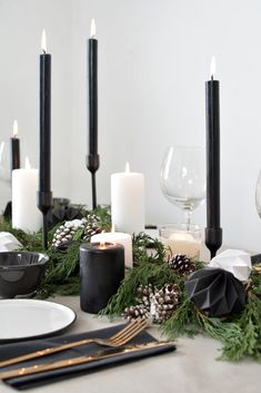 the table is set with candles, pine cones and other holiday decorating items on it