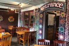 a restaurant with wooden tables and chairs in front of the door that says, entrance