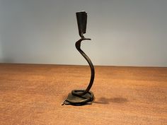 a metal candle holder sitting on top of a wooden table next to a black object