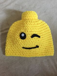 a crocheted yellow hat with black eyes