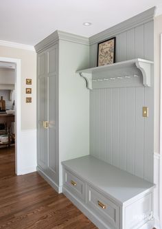 an empty room with some gray cabinets and shelves on the wall, along with wood flooring