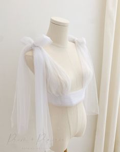 This beautiful shoulder cover shrug provides the stylish, classic, and unique finishing touch that every bride needs! Info + Details: Soft tulle in white or ivory ( almost always recommend ivory) Ribbon corset tied back to fit many sizes Straps are 2 separate tulle pieces that can be tied to fit as desired ( 100cm length each side)  ------------------------------------------------------------------------------------------ Custom made Items are final sale. Please contact us however if there is a Tulle Cover Up, Organza Cover Up Wedding, Tulle Shoulder Wrap, White Detachable Bow For Evening, Wedding Dress Bolero Tulle, Dress Separates, Bows Dress, Ribbon Corset, Wedding Bridal Dress