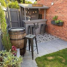 an outdoor bar with two stools next to it