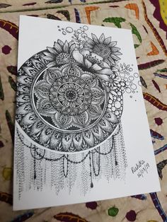 a black and white drawing of a flower on a piece of paper with an intricate design