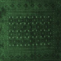 a green area rug with an intricate design on the top and bottom, it is very dark