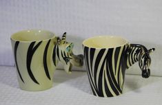 two zebra mugs sitting next to each other