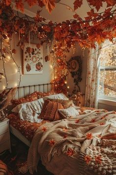 an unmade bed in a bedroom with lights strung from the ceiling and leaves on the wall