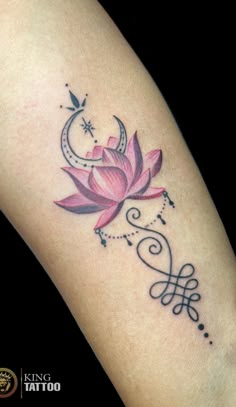 a woman's arm with a pink flower and crescent tattoo on the left side