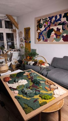 a living room filled with furniture and a rug on top of a wooden table in front of a window