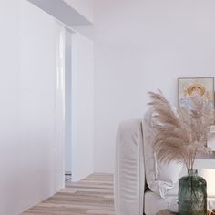 a living room with a white couch and some vases on the table next to it