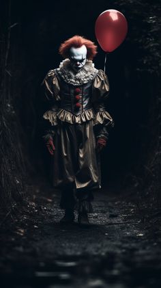 a creepy clown holding a red balloon standing in the middle of a dark forest path