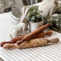 three wooden utensils sitting on top of a table next to potted plants