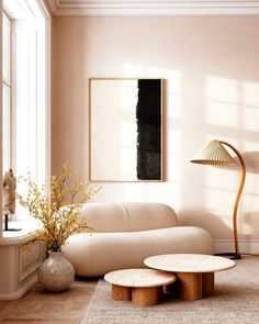 a living room filled with furniture next to a lamp and table in front of a window