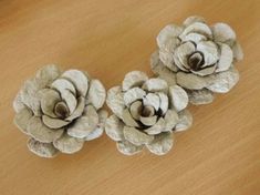 three white flowers sitting on top of a wooden table