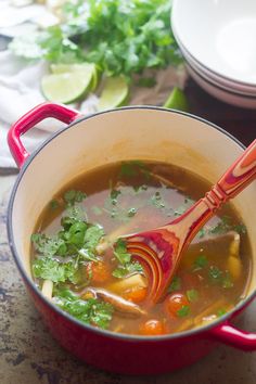 a red pot filled with soup on top of a table