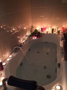 a bathtub filled with lots of candles and flowers