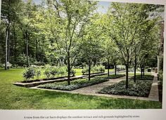 a garden with many trees and plants in it's center, surrounded by green grass