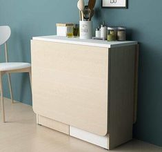 a white chair sitting next to a counter in a room with blue walls and wooden flooring