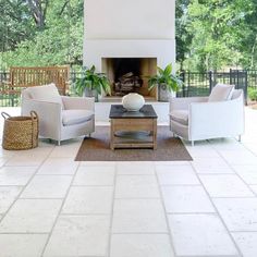 a living room filled with furniture and a fire place in the middle of a patio