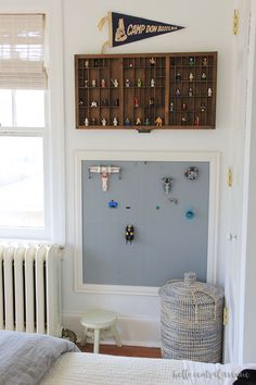 a room with a bed, table and wall hangings on the wall above it