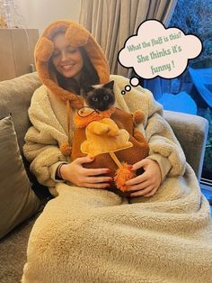 a woman sitting on a couch with a cat in her lap and a thought bubble above her head