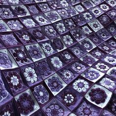 purple crocheted afghans with white flowers and hearts are arranged in the shape of squares