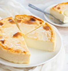 a piece of cheesecake on a white plate with a slice missing from the pie