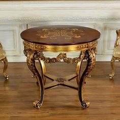 an ornately decorated table and chairs in a room with wood floors, white walls and gold trimmings