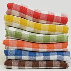 four towels stacked on top of each other in different colors and patterns, all folded neatly