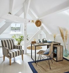 a chair and table in a room with an attic ceiling fan on the far wall