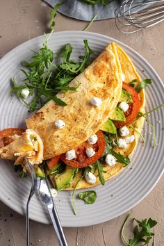 an omelet with tomatoes, lettuce and feta cheese