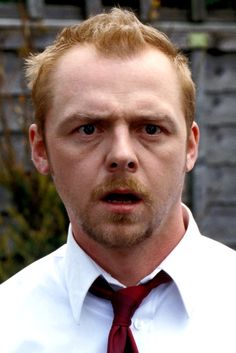 a man in a white shirt and red tie is making a face with his mouth open