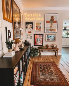 a living room filled with lots of pictures on the wall next to a wooden floor