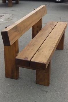 a wooden bench sitting on top of a parking lot