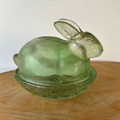 a glass rabbit sitting on top of a wooden table