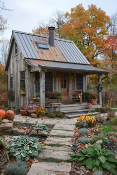 a small house with a metal roof and stone steps leading up to the front door