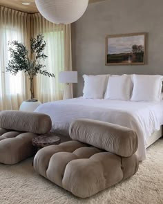 a large bed sitting in the middle of a bedroom next to a window with curtains