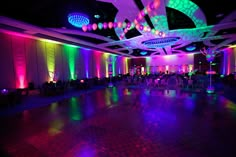 an empty dance floor is lit up with colorful lights