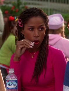 a woman in a pink dress is holding a bottle of water