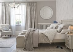 an image of a bedroom with white furniture and curtains on the window sill in front of the bed