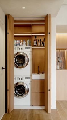 a washer and dryer in a room with wood flooring on the walls