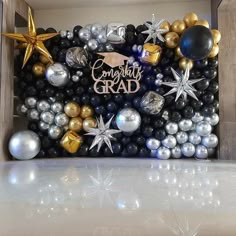 graduation balloons and decorations are displayed in a cardboard box with congratulations grad written on it