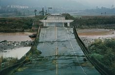 the road is wet and muddy with water coming out of it's spillway