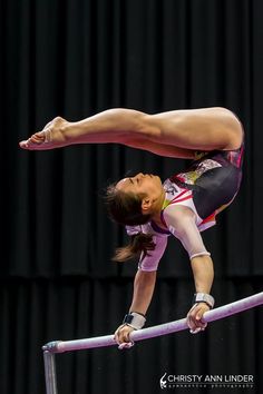 a woman is performing on the balance bars