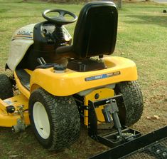 a yellow lawn mower sitting in the grass