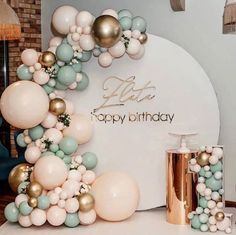 a birthday party with balloons and confetti on the table, including an arch