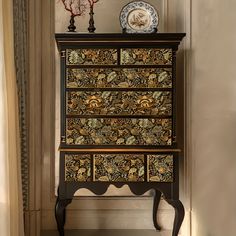 an ornately decorated chest of drawers in the corner of a room with a plate on top