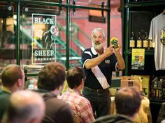 a man holding up a beer in front of a group of people