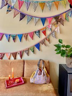 a living room filled with furniture and lots of colorful flags hanging from the wall above