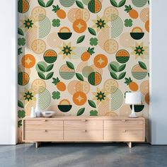 an orange and green wallpaper in a room with a lamp on the sideboard